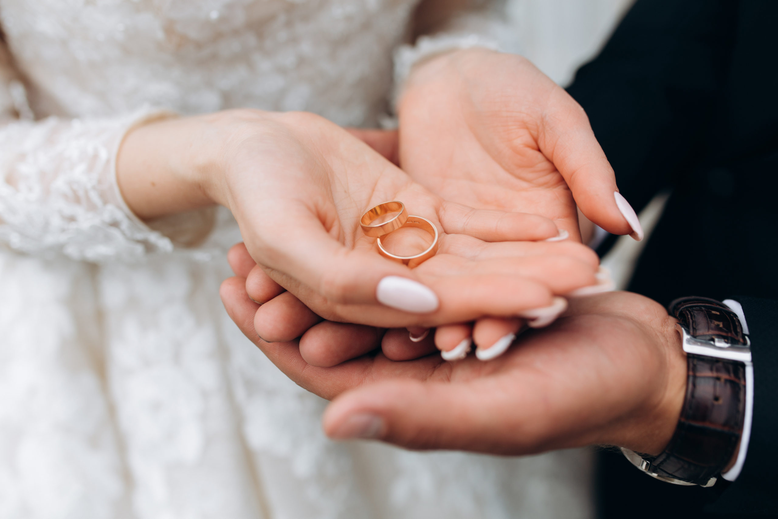 Brudgommen holder brudens hænder, hvor er to vielsesringe
